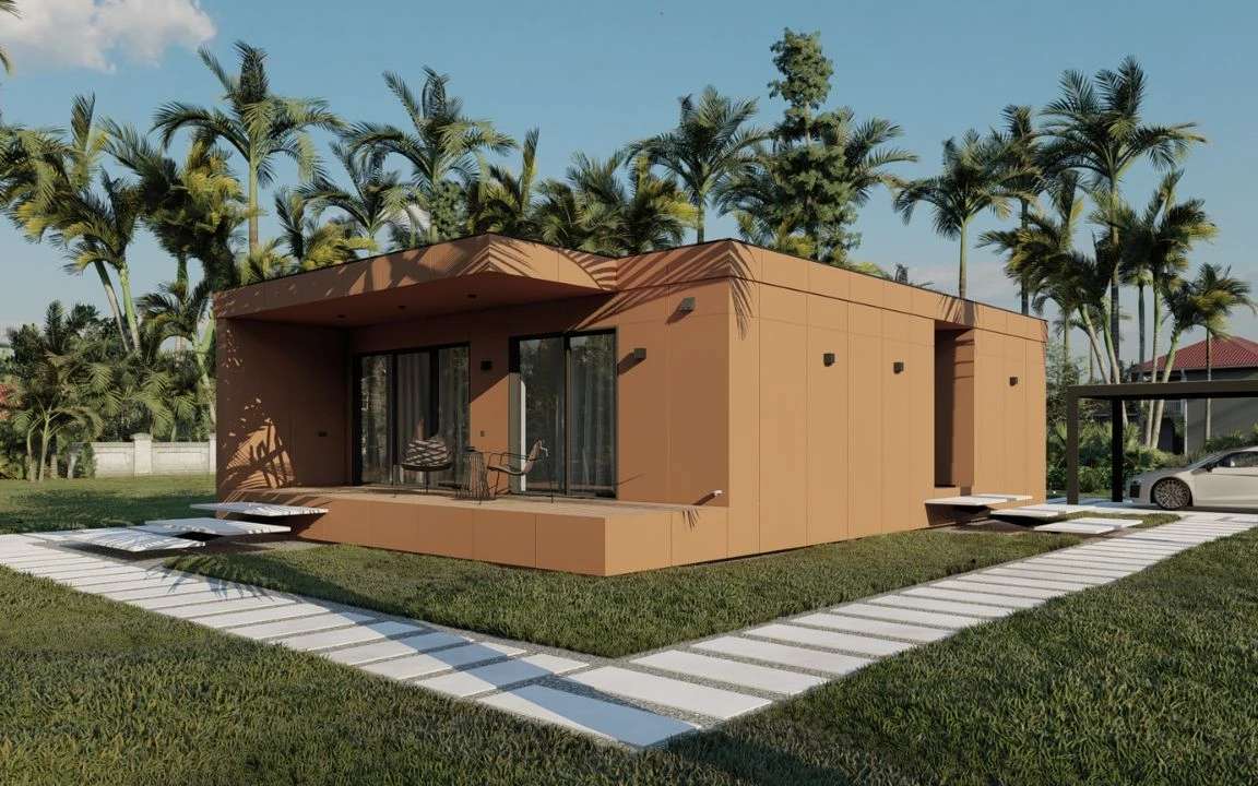 Modern orange-toned modular house with geometric lines, a wooden terrace, and a white stepping-stone walkway, surrounded by grass and palm trees.