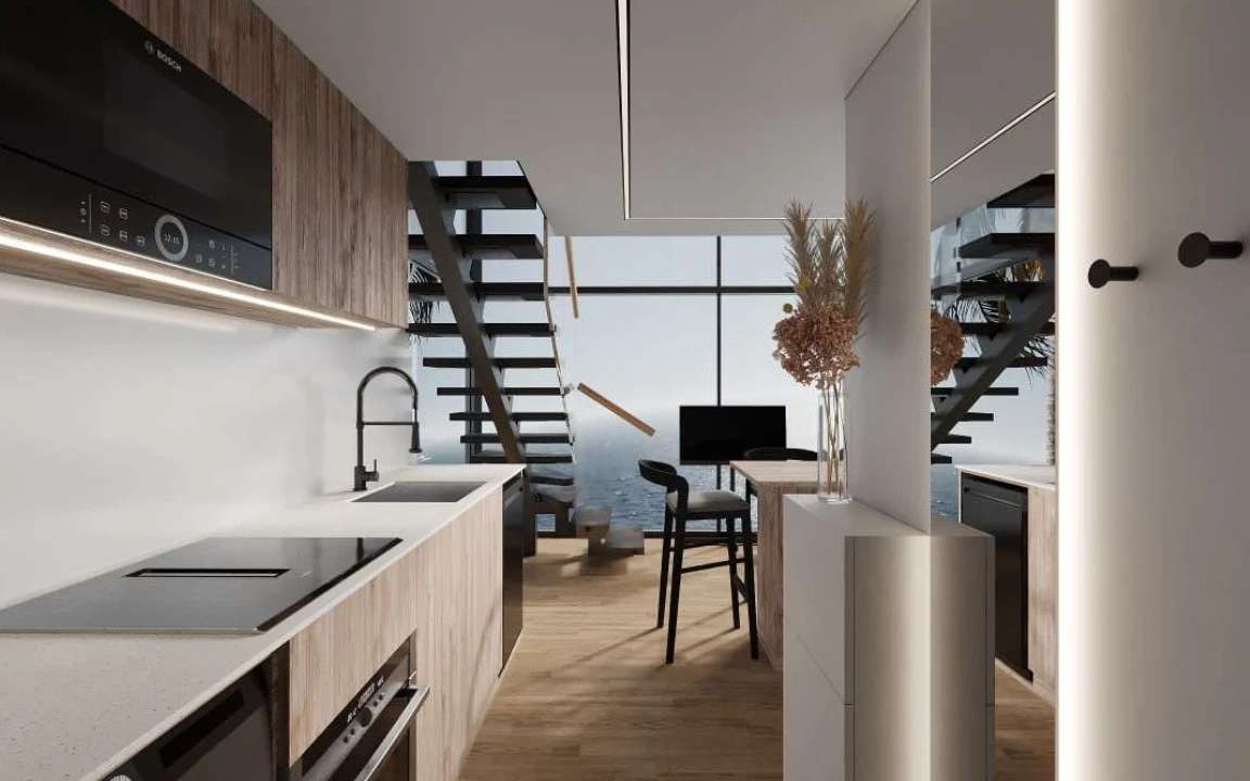 Kitchen and dining area of the  modular house with a modern staircase and island