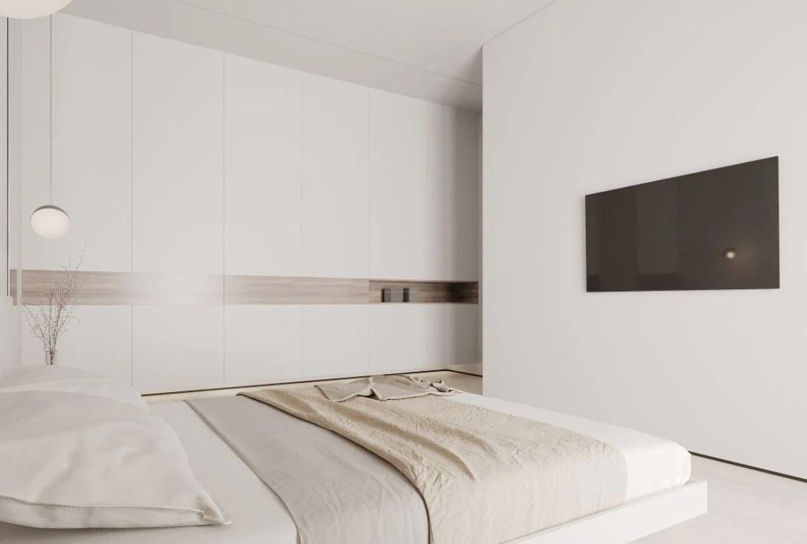 Bedroom with floor-to-ceiling wardrobes and mounted TV opposite bed