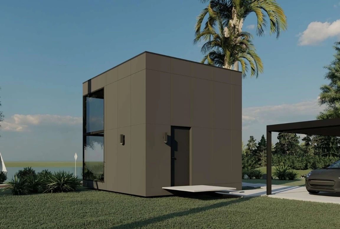 Side view of the  modular house showing the black exterior and front entrance