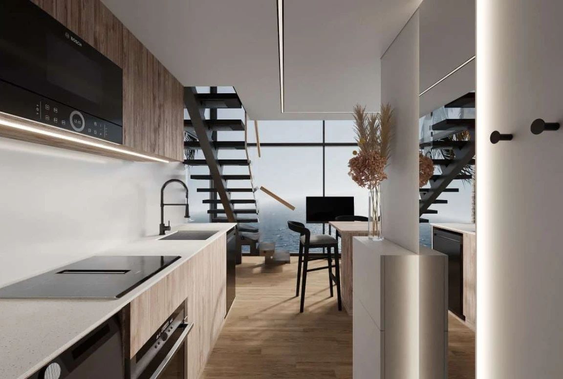 Kitchen and dining area of the  modular house with a modern staircase and island